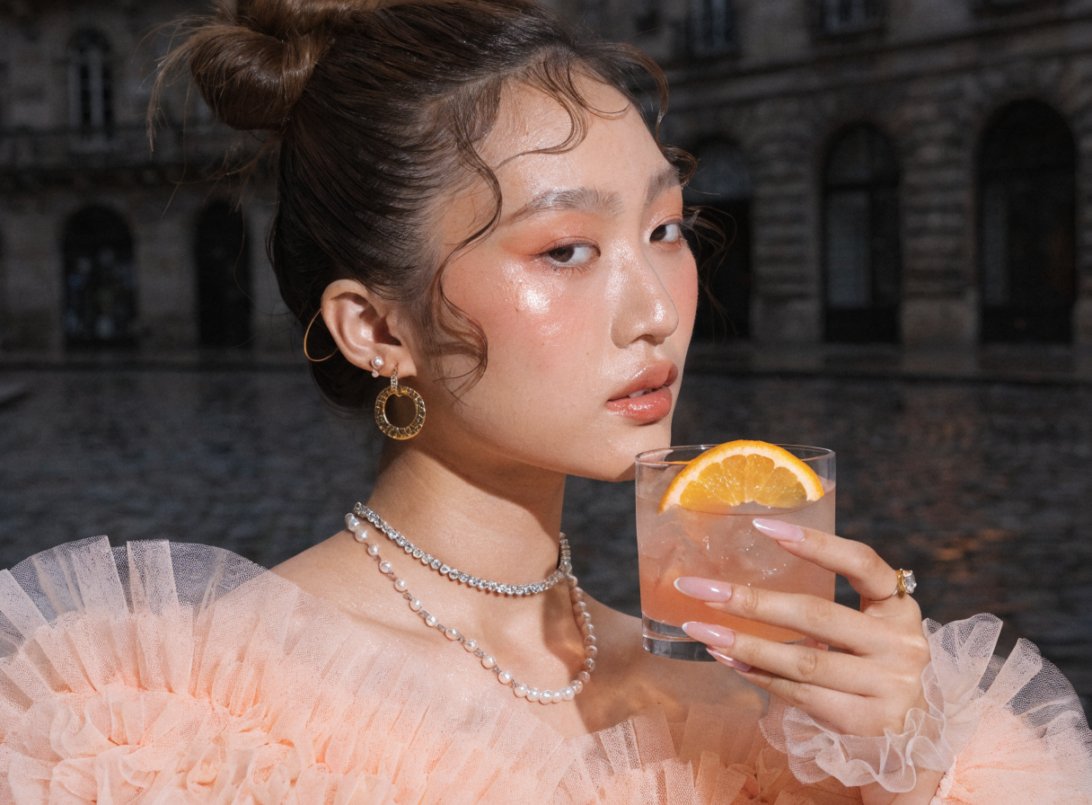 Glamorous fashion model showcasing warm peach makeup tones with a soft glow.